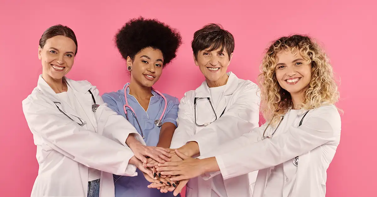 Group of women physicians holding hands.